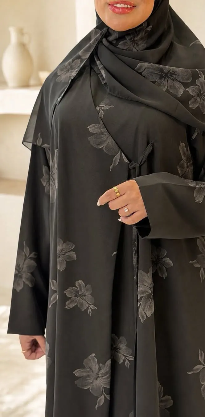 Model in a black abaya with a soft grey floral print and side tie