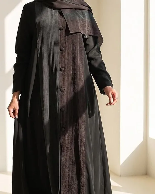 Pleated brown front panel and covered buttons of the black abaya