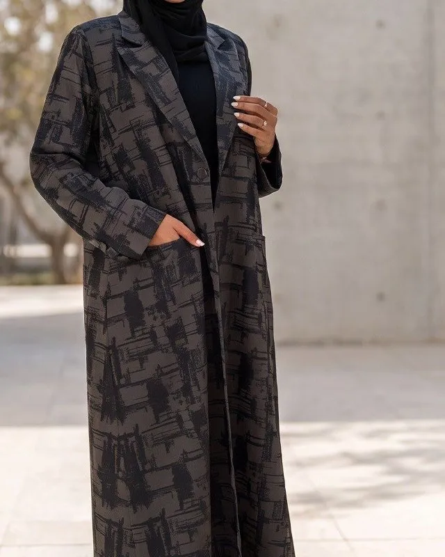 Lapels, button and pocket of the brushstroke print coat abaya